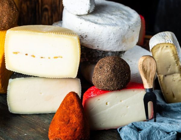 several types of cheese placed on a wooden chopping board