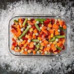 frozen vegetables in a tray, on a bed of ice
