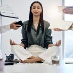 Woman meditating in a stressful work environment