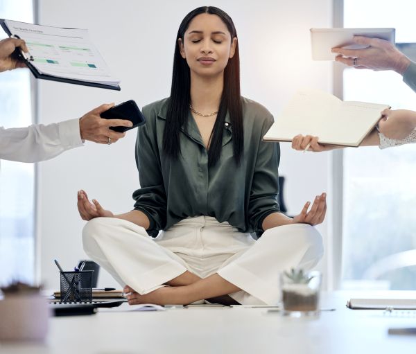 Woman meditating in a stressful work environment
