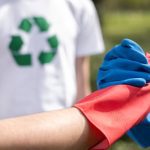 doua persoane care isi strang mainile cu manusi de curatenie si semn de recilare in spate