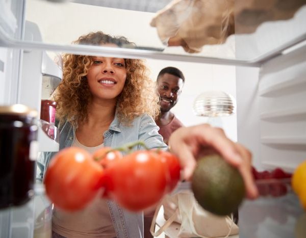 femeie care cauta in frigider alimente pentru a face mancare